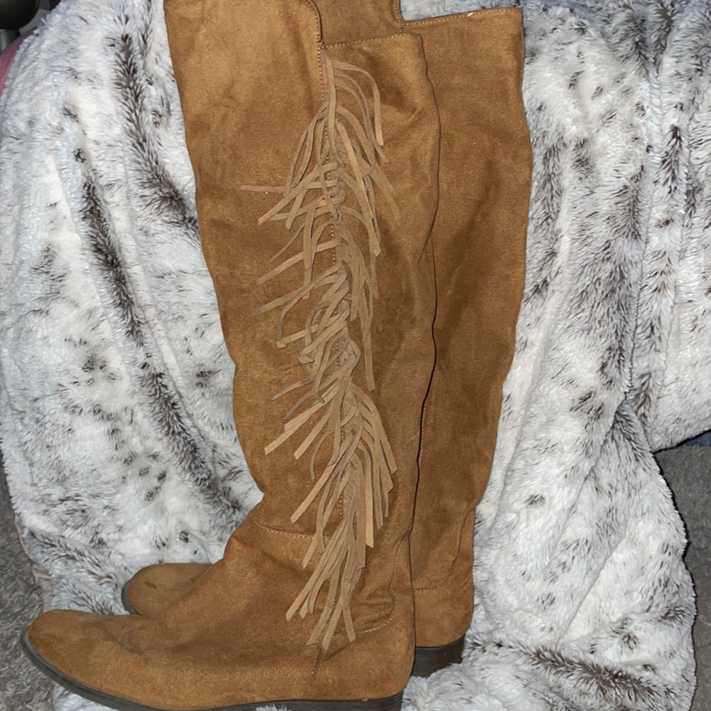 Knee high brown boots with fringe on the side